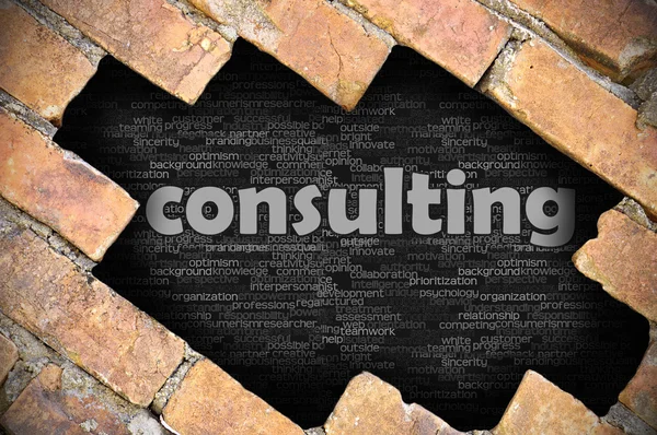 Hål i tegelväggen med ordet consulting — Stockfoto