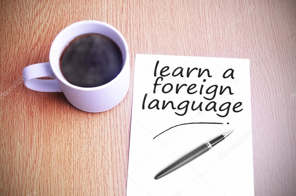 Coffee on the table with note writing learn a foreign language