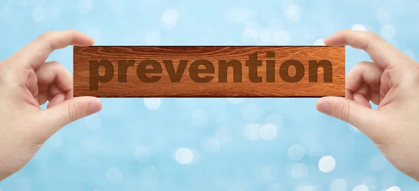 Handen met een hout graveren met woord preventie — Stockfoto