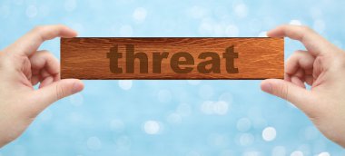 Bir ahşap holding eller kelime tehdidi ile basık