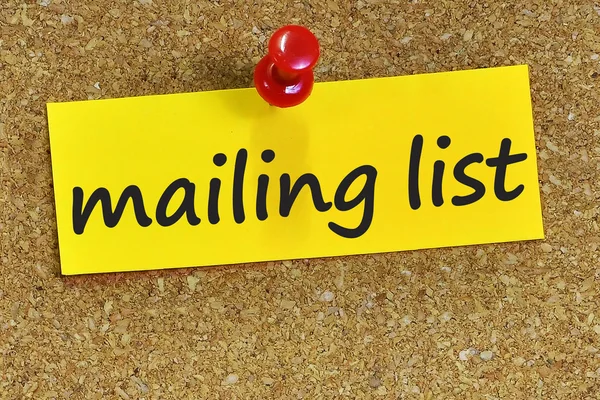 Mailing list palavra em papel de carta amarelo com fundo de cortiça — Fotografia de Stock