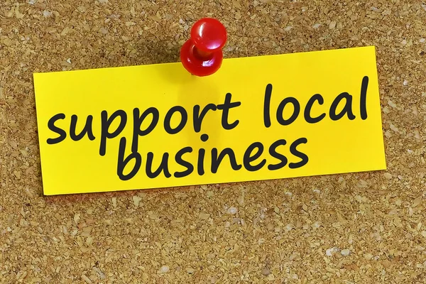 Apoyar la palabra local de negocios en papel de apunte amarillo con corcho backgr — Foto de Stock
