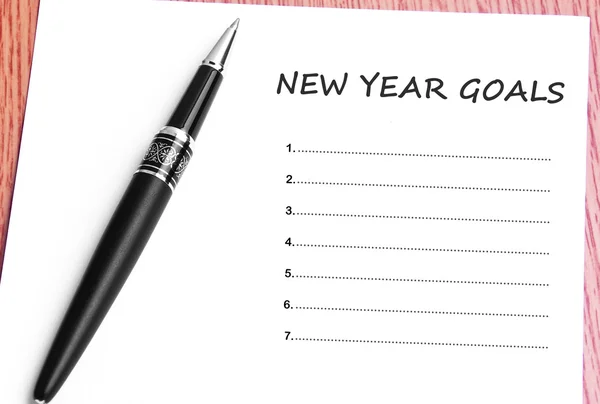 Pen  and notes paper with new year goals — Stock Photo, Image