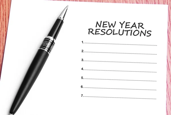 Ручка и бумага с новогодними резолюциями — стоковое фото