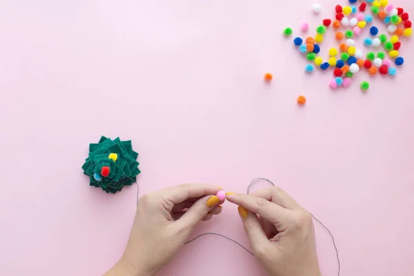 Evde küçük keçeli Noel ağacı nasıl yapılır? Adım adım talimatlar. Eller DIY projesini takip etmeyi kolaylaştırıyor. 7. adım: Noel ağacını süsle