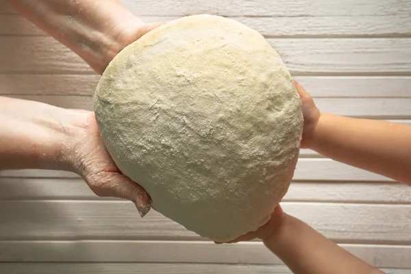 Yaşlı bir kadının elleri küçük kızlara ekmek hamuru iletir. Nesiller arası bağlantı. Tecrübe, bilgi ve sevgi kavramı eski nesilden genç kuşağa aktarılır..