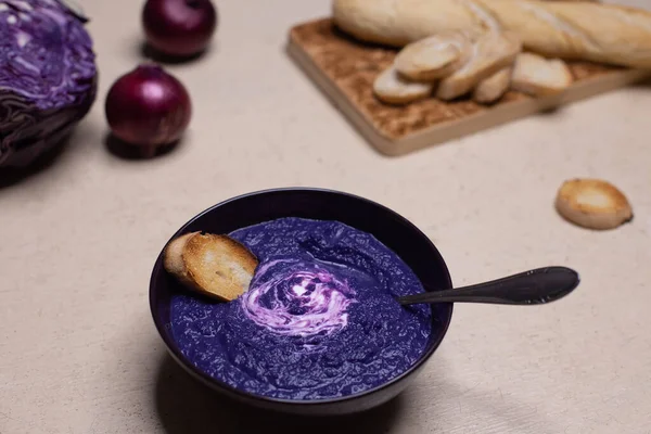 Parlak kırmızı lahana kremalı yemek fotoğrafı. Bebeğim, lahana ve soğan yakınlarda yatıyor. Mor yemek.