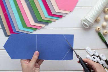 Evde işlemeli harflerle keçeli bayrak nasıl yapılır? Adım adım talimatlar. Eller DIY projesi yapıyor. Dördüncü adım: Bayraklarını keçeden kes
