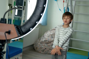 Sosyal medya için bir çocuk dansını telefonuyla filme alıyor..