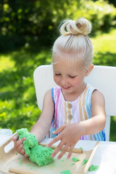 夏日里，一个金发可爱的小女孩在后院玩动感沙子 — 图库照片
