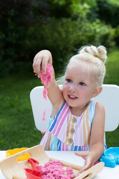 夏日里，一个金发可爱的小女孩在后院玩动感沙子 — 图库照片