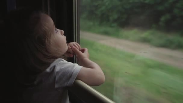 Retrato de linda menina olhando pela janela de um trem principal. — Vídeo de Stock