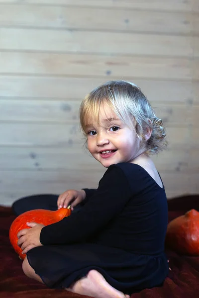 Petite fille assise avec des citrouilles. Fête d'Halloween — Photo
