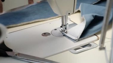 Kadın eli dikiş makinesine dikilir.