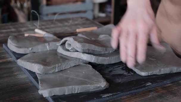 Женщина с руками кладет кусочки глины — стоковое видео