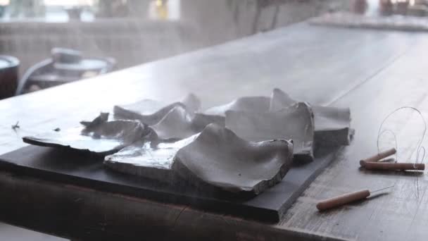 Pezzi di argilla sulla tavola spruzzare con acqua — Video Stock