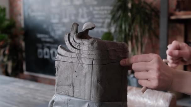 Samica rzeźbiarza tnie glinę na kawałki metalowym sznurkiem. — Wideo stockowe