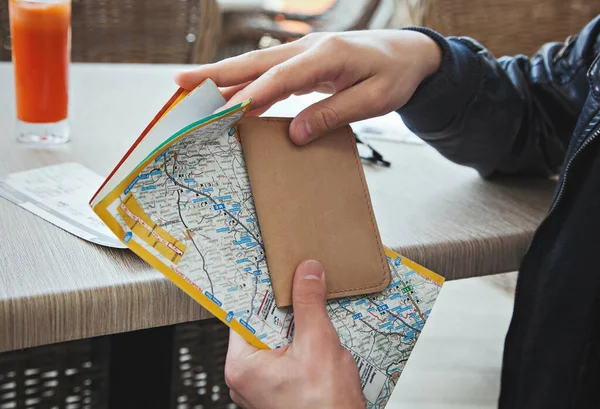 Man vid bordet med en plånbok och kartan — Stockfoto