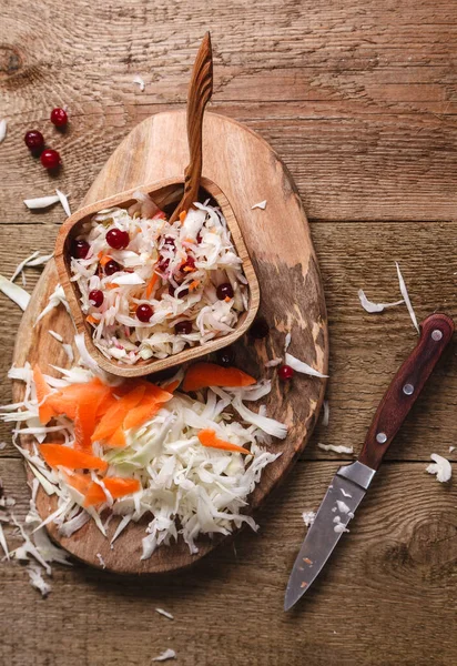 Cavolo e carote tritate con un coltello su una tavola di legno — Foto Stock