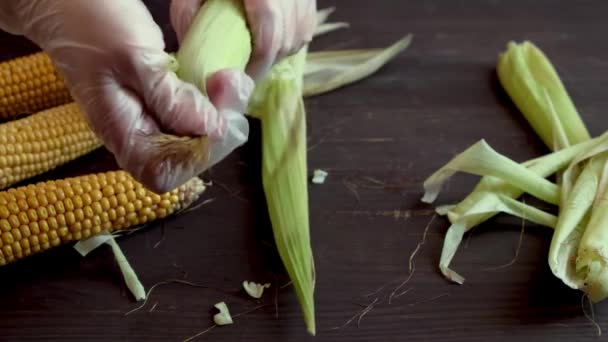 Het proces van het reinigen van rauwe maïs van bladeren — Stockvideo