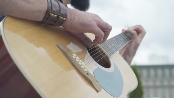 Close-up van mannelijke blanke vingers op gitaarsnaren. Onherkenbare straatmuzikant die buiten muziekinstrumenten bespeelt. Hobby en lifestyle concept. — Stockvideo