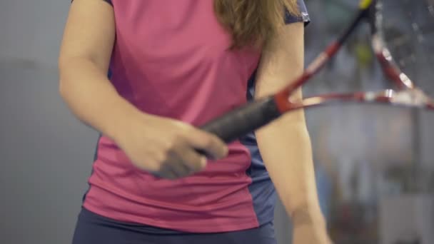 Spor salonunda tenis topunu servis etmeye hazırlanan ciddi konsantre beyaz kadın portresi. Kamera aşağı yukarı hareket ediyor. İçeride antrenman yapan kendinden emin bir kadın.. — Stok video