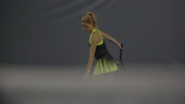 Blond jong vrouwtje serveert bal in groot tennis. Portret van een geconcentreerde blanke sportvrouw die racket en balsport speelt in de sportschool. Indoor training van mooie slanke vrouw. — Stockvideo
