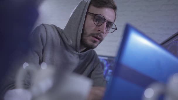 Portret van vermoeide programmeur in een bril geeuwt en het nemen van lege beker zonder koffie. Jonge uitgeputte blanke man overwerkt in IT-kantoor 's nachts. Gericht hacker hacken online site. — Stockvideo