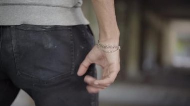 Yumruğunu sıkan kızgın bir adamın eli. Terk edilmiş harabelerde duran tanınmaz halde agresif bir adam. Saldırganlık ve öfke kavramı.