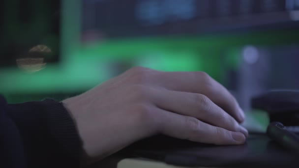 Primo piano vista laterale del maschio mano caucasica clic del mouse del computer nel buio. Uomo irriconoscibile che hackera i dati online al chiuso. Programmatore professionista software di codifica. — Video Stock