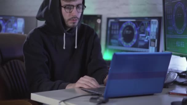믿음직 한 젊은 해커가 노트북을 닫고 한숨을 쉬고 있습니다. 안경과 후드를 쓴 코카서스 남성이 온라인 웹 사이트를 해킹하고 USB 기기의 플러그를 뽑는 모습. 가상의 보안. — 비디오