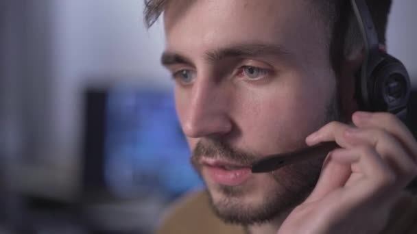 Vista lateral de primer plano del hombre caucásico hablando con auriculares. Soporte técnico profesional empleado de consultoría cliente o cliente en la oficina. Especialista en TI que trabaja en contact center. — Vídeo de stock