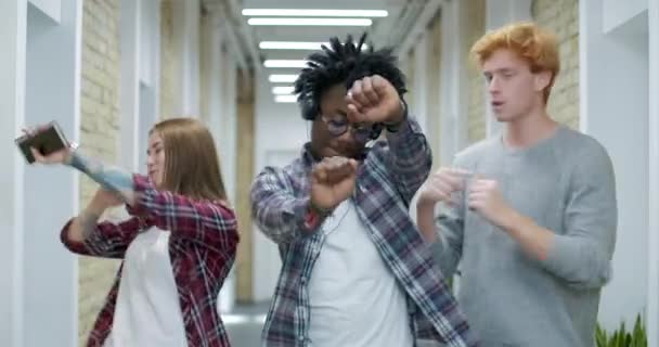 Mutlu çok ırklı iş arkadaşları ofis koridorunda dans edip beşlik çakıyor. Pozitif çok ırklı meslektaşların portresi başarıya seviniyor. Başlangıç konsepti. Sinema 4k ProRes Merkezi. — Stok video