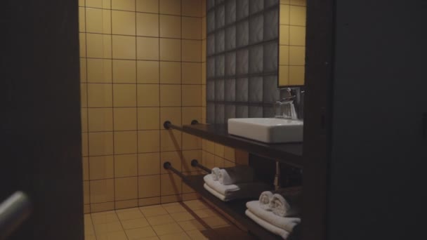 Interiores de casa de banho confortável limpo no quarto de hotel. Lavatório de estilo moderno, chuveiro e armário de água no albergue. Não há pessoas. Turismo e conceito de viagem. — Vídeo de Stock