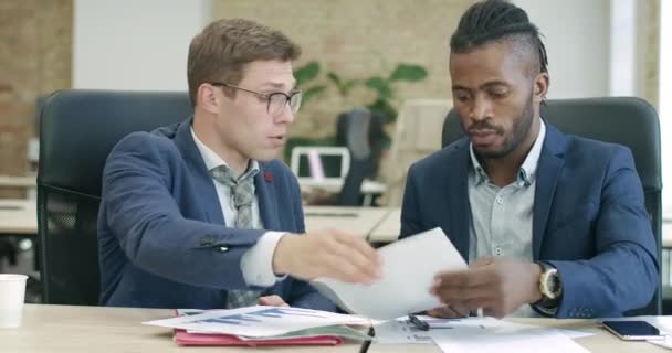 真剣に成功した白人とアフリカ系アメリカ人のビジネスマンは、オフィスで文書に署名し握手。自信のある男が商売をしている。シネマ4k｜ProRes HQ. — ストック動画