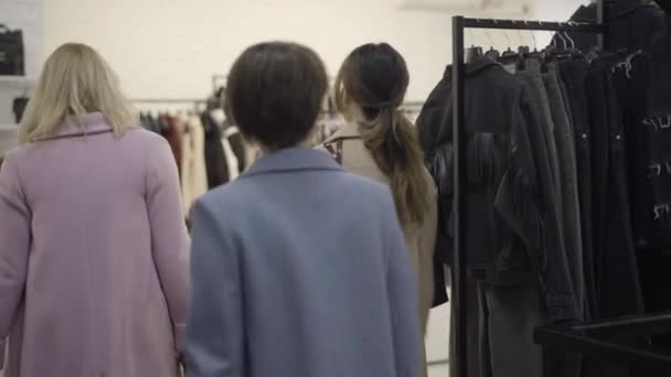 Vue arrière des clients riches entrant dans le magasin de vêtements. Des femmes caucasiennes confiantes marchant en magasin et parlant. Concept de Black Friday ventes et achats. — Video