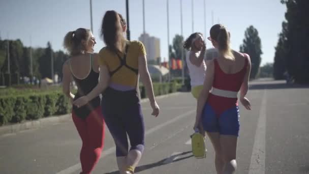 Повернення до розслаблених щасливих друзів 1980-х років, які гуляють по сонячній міській дорозі з дренажною стрічкою і танцюють під музику диско. Обачні кавказькі чоловіки і жінки, які виходили на вулицю в літній день.. — стокове відео