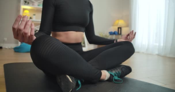 Femme mince méconnaissable assis dans la pose de yoga sur le tapis d'exercice. S'adapter à la formation sportive caucasienne à la maison à l'intérieur. Siège social Cinema 4k ProRes. — Video