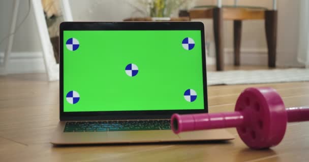 Κοντινό πλάνο του φορητού υπολογιστή πράσινη οθόνη με ροζ αλτήρα που βρίσκεται στο πάτωμα. Η ταινία μέτρησης πέφτει κάτω. Chromakey του αθλητισμού ή της υγειονομικής περίθαλψης ιστοσελίδα. Κινηματογράφος 4k ProRes HQ. — Αρχείο Βίντεο