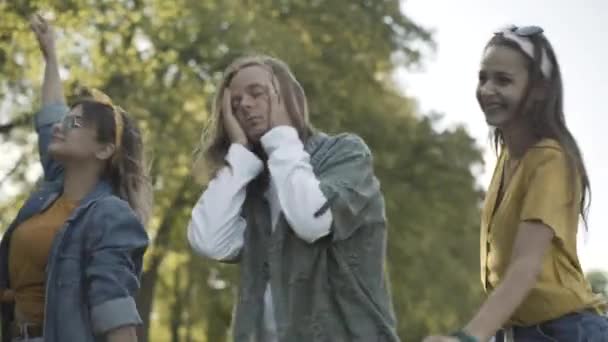 Groep hippie junkies ontspant zich op een zonnige zomerdag buiten. Onzorgvuldige blanke jaren zestig mannen en vrouwen in het zonlicht. Retro tegencultuur en verslavingsconcept. — Stockvideo