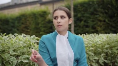 Dışarıda sigara içen genç hostes portresi. Mavi üniformalı zarif, ince, beyaz bir kadın seyahat sırasında mola veriyor. Turizm ve yaşam tarzı.
