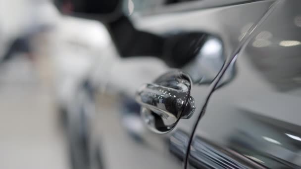 Primer plano de la mano caucásica masculina que abre la puerta del coche. Hombre joven irreconocible abre negro lujoso vehículo tirando de la manija. Concepto de la industria del automóvil. — Vídeo de stock