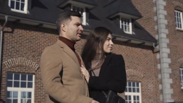Ritratto di ricco uomo d'affari caucasico in piedi con giovane bella moglie sul cortile della nuova casa di lusso e parlando. Un uomo ricco e sicuro che compra immobili per la famiglia. Stile di vita e concetto di successo — Video Stock