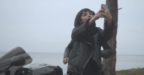 Portrait de joyeuse jeune femme caucasienne prenant selfie comme Moyen-Orient homme joyeux venir et faire des cornes sur sa tête. Heureux jeune couple interracial de motards s'amuser. Siège social Cinema 4k ProRes. — Video