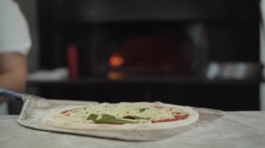 Çiğ pizzayı, tanınmayan bir aşçıyla pişirme küreklerinin üzerine koyup mutfaktaki fırına atıyorlar. Restoranda ya da pizzacıda lezzetli İtalyan yemekleri pişiren profesyonel Kafkas şefi..