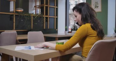 Kafkasyalı güzel bir kadının çizimleri analiz etmesi ve telefonda konuşması, restoranda oturması. Kendine güvenen ciddi iş kadını tatilde çok çalışıyor. Sinema 4k ProRes Merkezi.