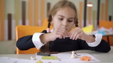 Okulda plastik heykel yapan liseli kızların portresi. Devlet okulunda resim dersi sırasında beyaz bir kızın kilde modellik yapmasına odaklanmış. Eğitim ve yaratıcılık kavramı.
