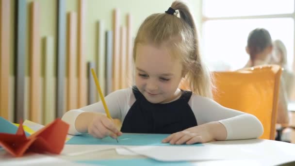 Cute szczęśliwy dziewczyna rysunek obraz z kolegami z klasy siedzi w tle. Portret pięknej białej uczennicy na lekcji sztuki w szkole. Koncepcja talentu i kreatywności. — Wideo stockowe