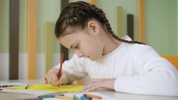 Nahaufnahme von ziemlich konzentrierter Mädchenmalerei mit Bleistift am Schreibtisch. Porträt eines fokussierten kaukasischen Schülers, der während des Kunstunterrichts in der Schule ein Bild zeichnet. Bildungs- und Talentkonzept. — Stockvideo