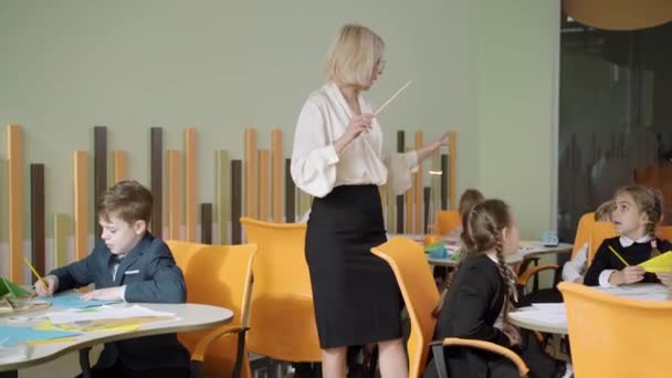 Professeur de musique positive conduisant et chantant avec les enfants en classe. Belle femme caucasienne enseignant des écoliers à l'école publique. Concept de créativité et tutorat. — Video